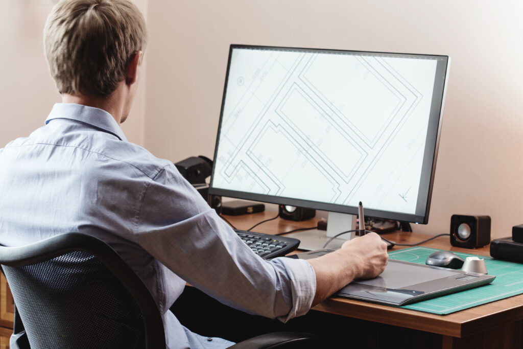 Graphic designer using digital tablet and computer in office or